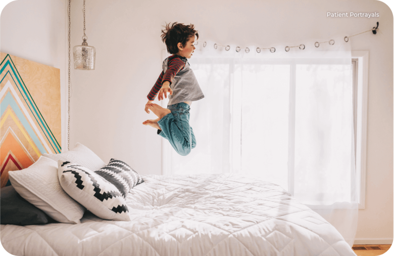 Image: Young Boy Jumping On Bed